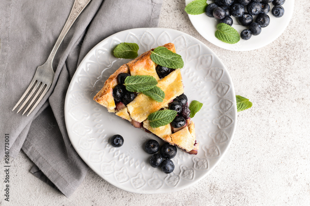 Piece of tasty blueberry pie on light background