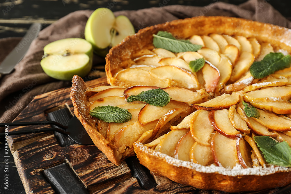 Tasty apple pie on wooden board, closeup