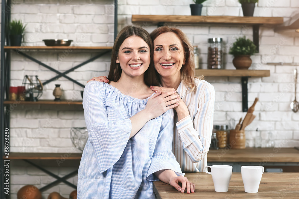 Happy mother and daughter in kitchen at home