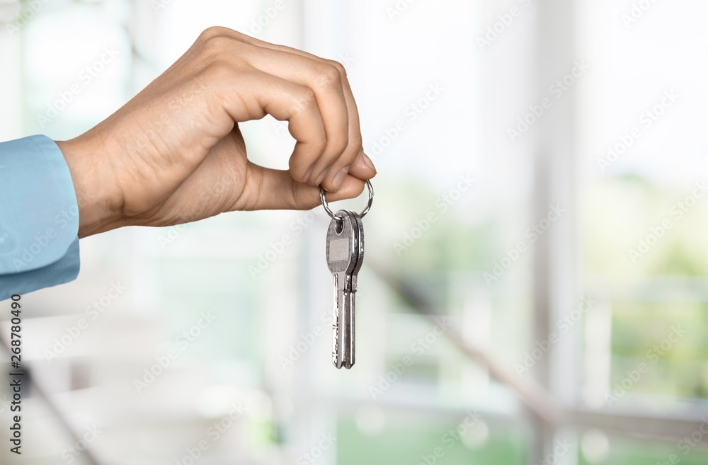 Hand Holding Metal House Key on white background