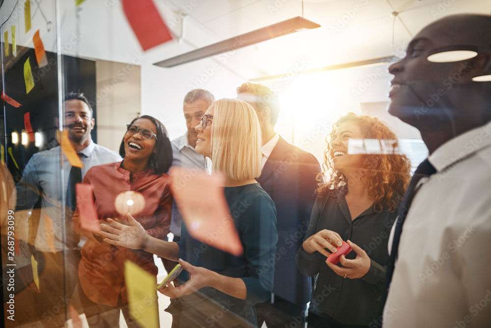 Smiling businesspeople brainstorming together on an office glass