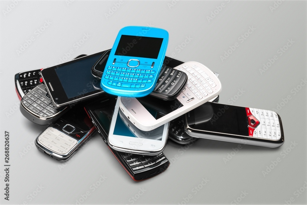 Pile of old smartphones on wooden background