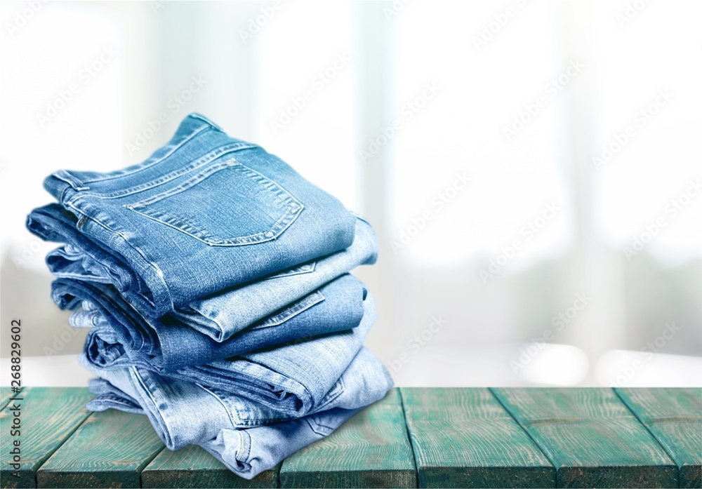 Pile of blue jeans over white background