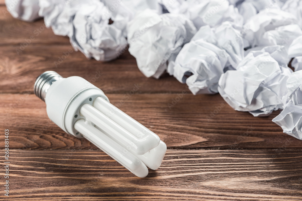 Ideological concept with wastepaper light bulb on wooden table