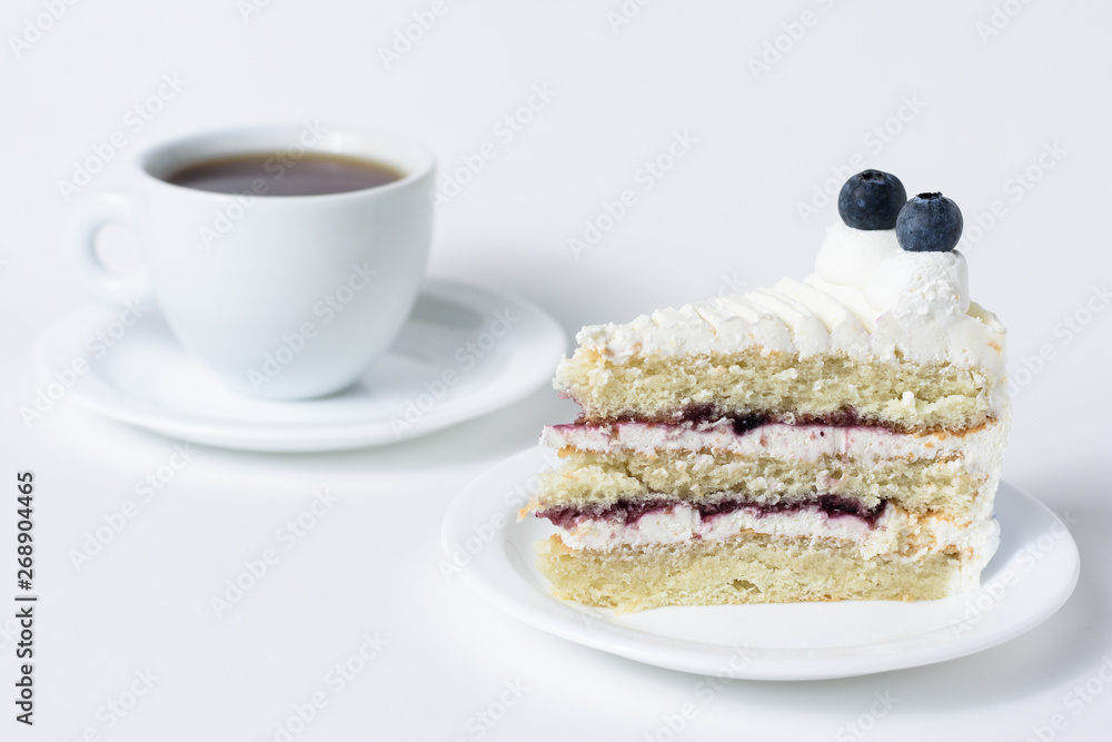 Blueberry cheesecake slice with tea front view on a white background