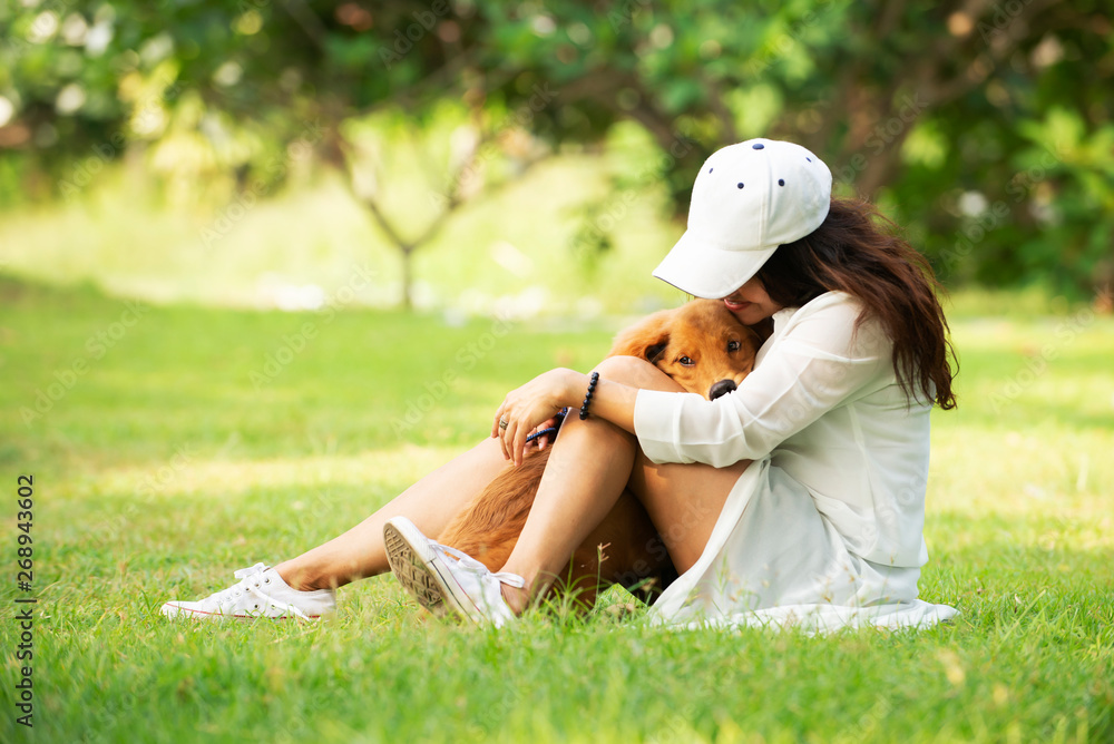 Cheerful pretty asia woman with her dog Golden Retriever dog   playing together outdoor at park,life