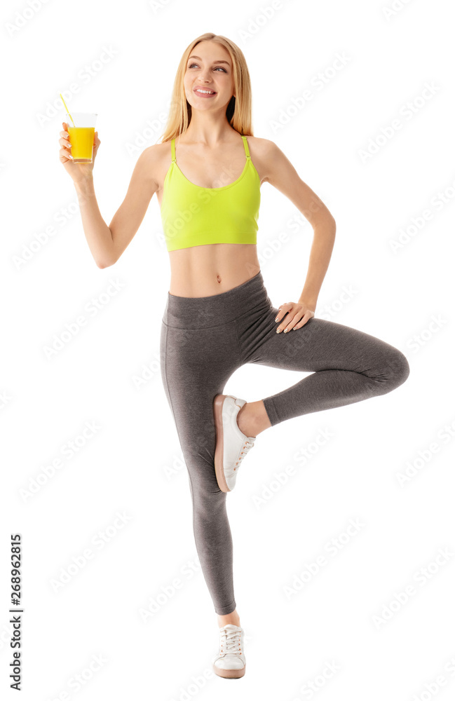 Sporty young woman with glass of juice on white background