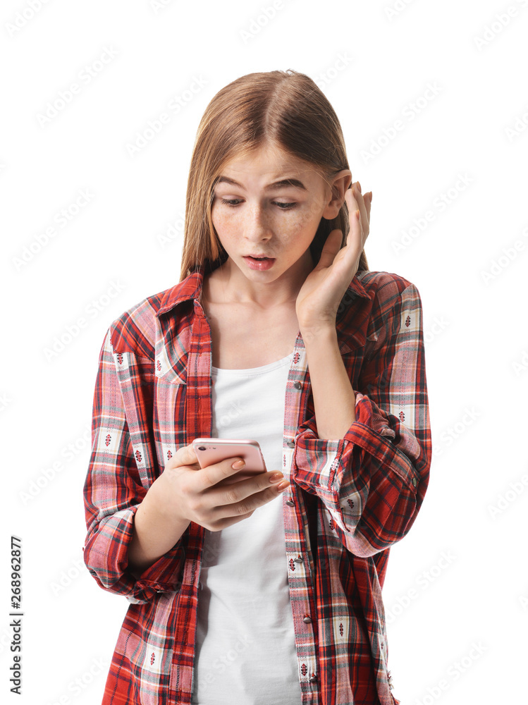 Shocked teenage girl with mobile phone on white background