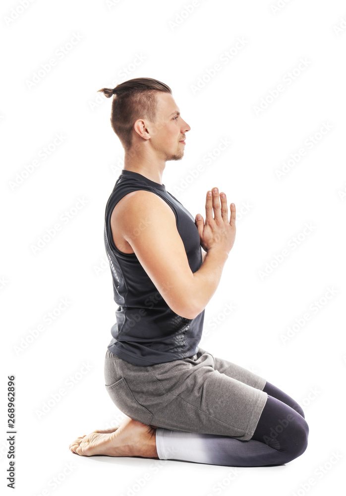 Sporty man practicing yoga on white background