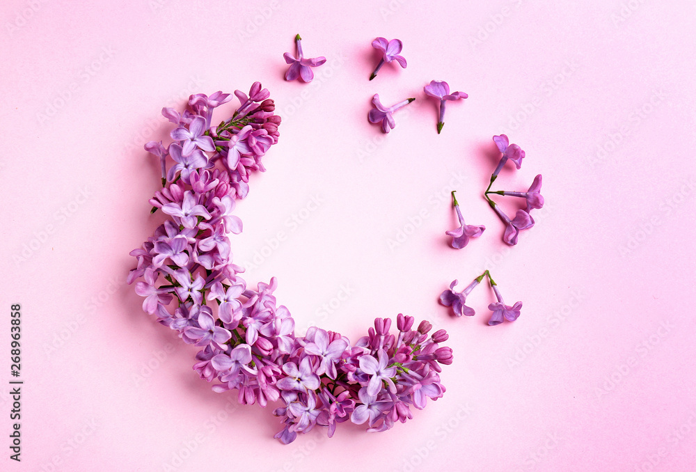 Frame made of beautiful lilac flowers on color background