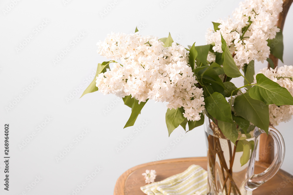 浅色背景下，椅子上的罐子里有美丽的淡紫色花朵