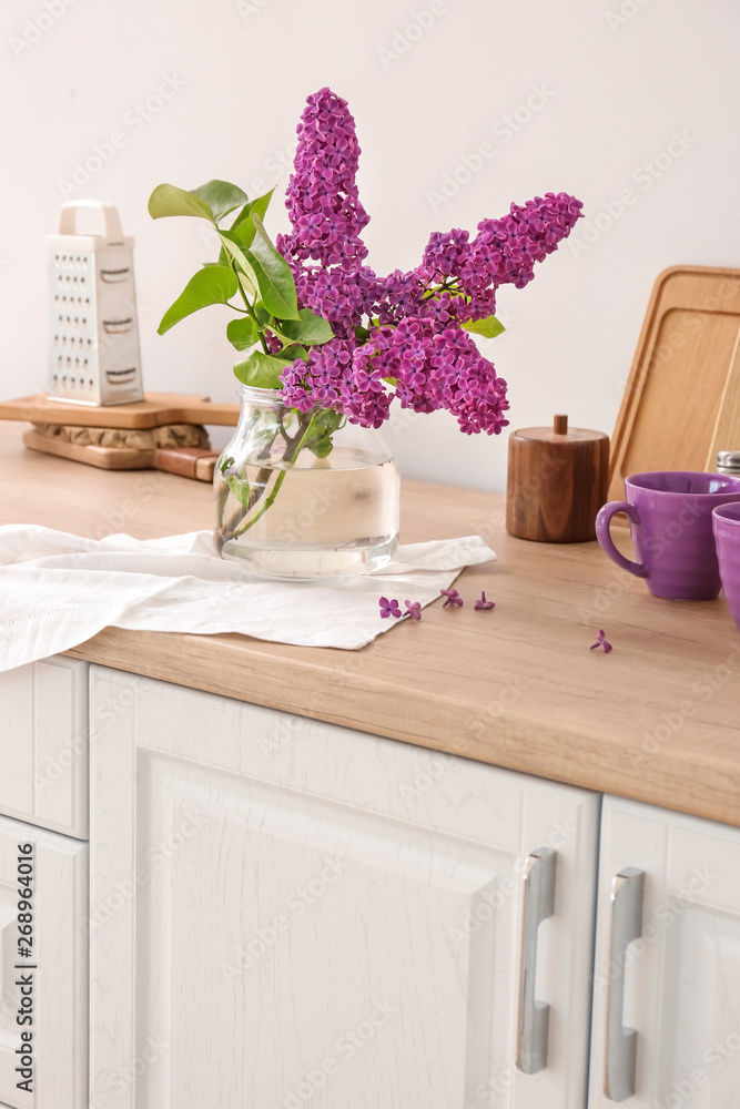 Beautiful lilac flowers on counter in kitchen