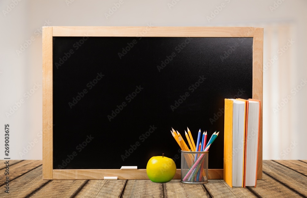 Colorful school supplies on blackboard background