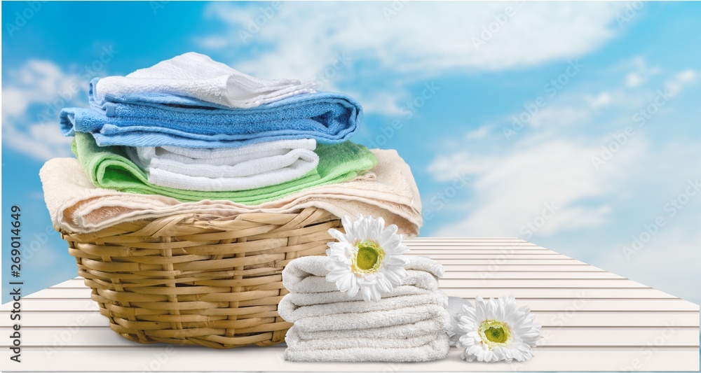 Laundry Basket with colorful towels on background