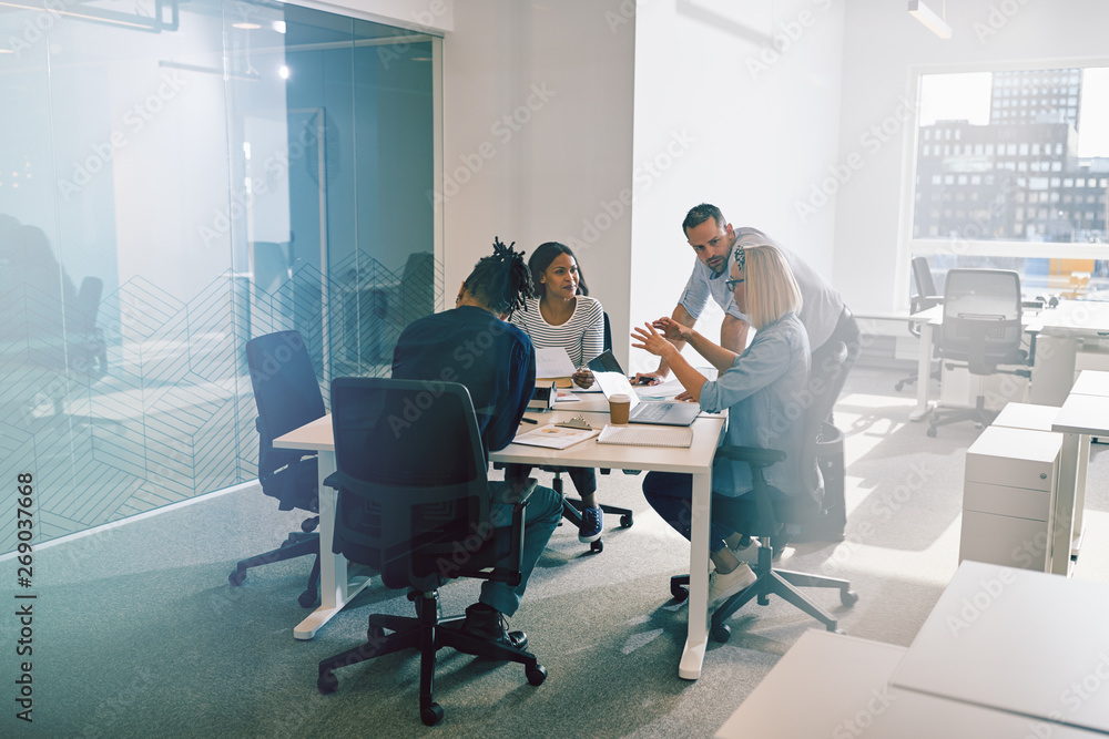 Work colleagues discussing business together during an office me