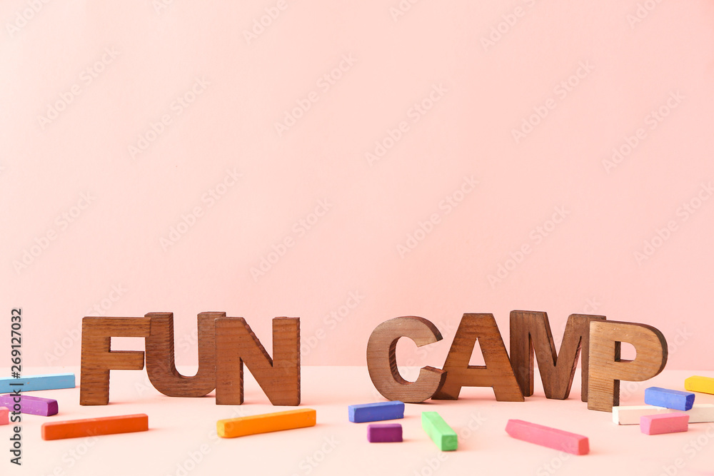 在彩色背景下，桌子上的蜡笔和文字FUN CAMP