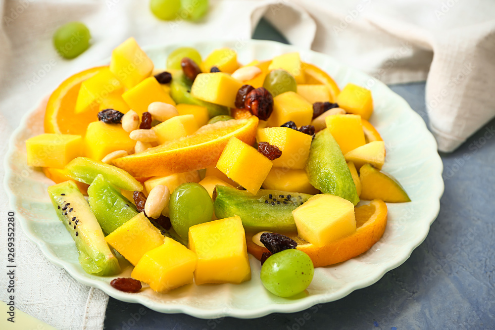 Plate with tasty mango salad on table