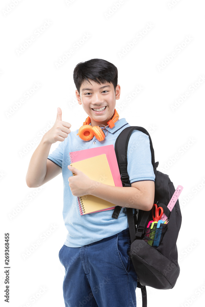 Smiling little student boy in blue polo t-shirt in with books and bag.