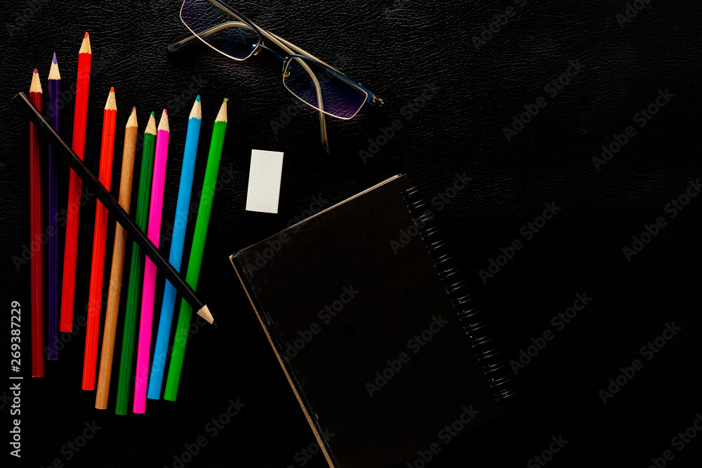 Business objects of pencils, paper note,and glasses on black leather background