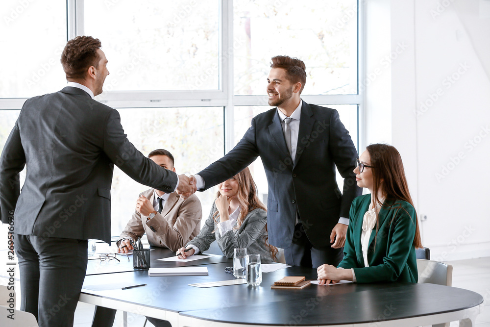 Human resources manager shaking hands with applicant after successful interview