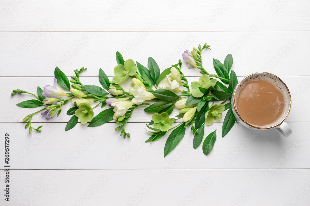 白色木质背景上的美丽花朵和一杯咖啡