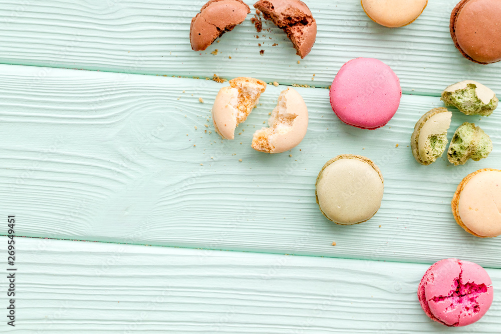 Macarons design on mint green wooden background top view space for text