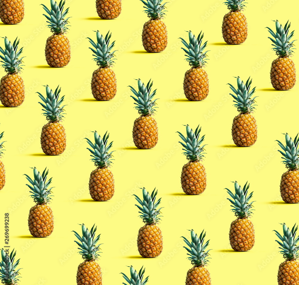 Many pineapples on a solid color background