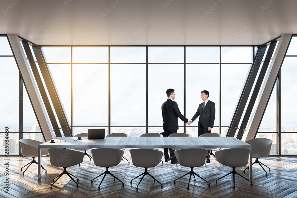 Businesspeople shaking hands in meeting room