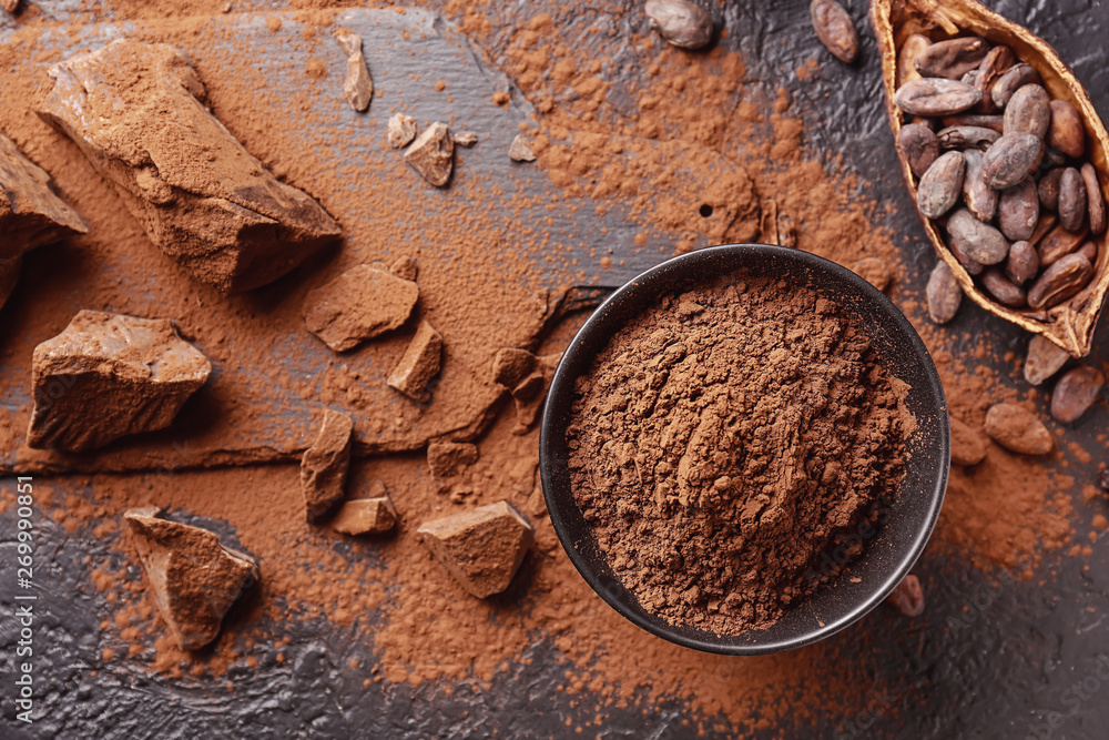 Composition with cocoa powder, beans and chocolate on table