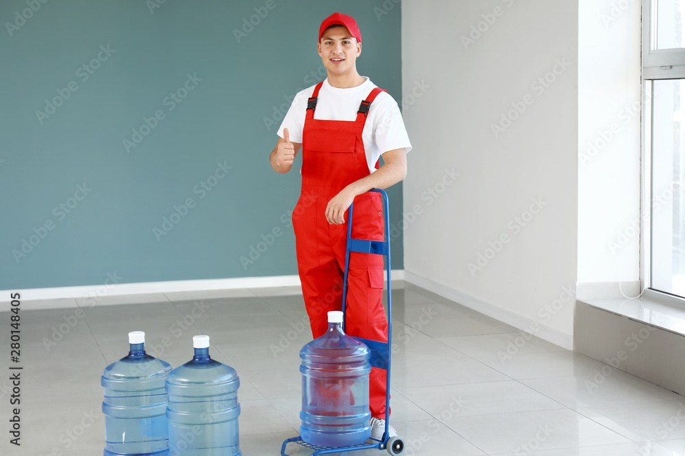 Delivery man with bottles of water indoors