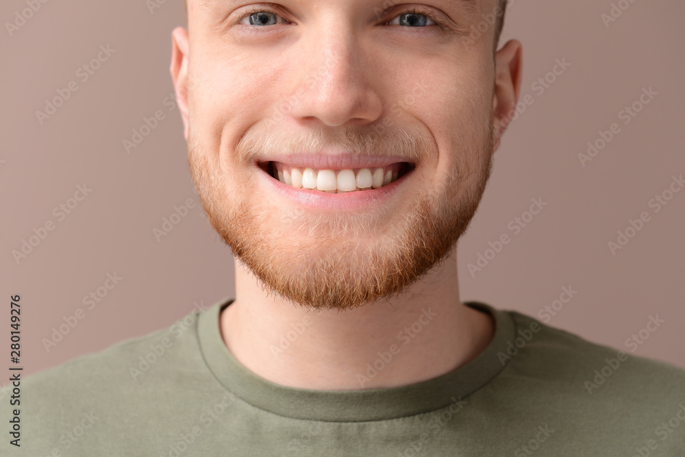 Young man with healthy teeth on color background