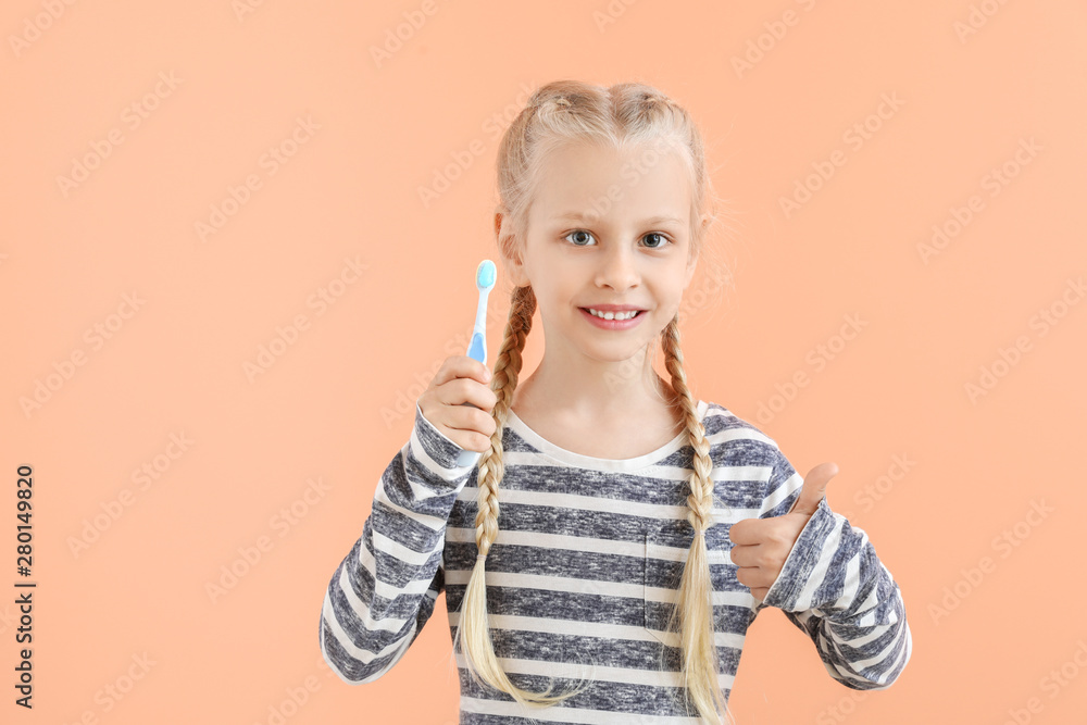 Little girl with toothbrush on color background