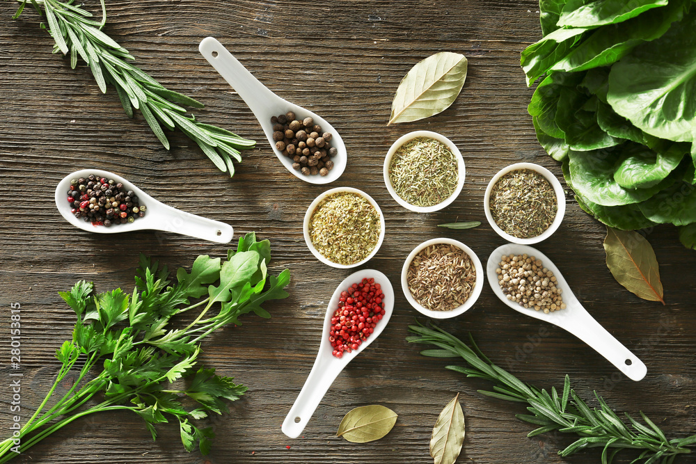 Different herbs and spices on wooden background