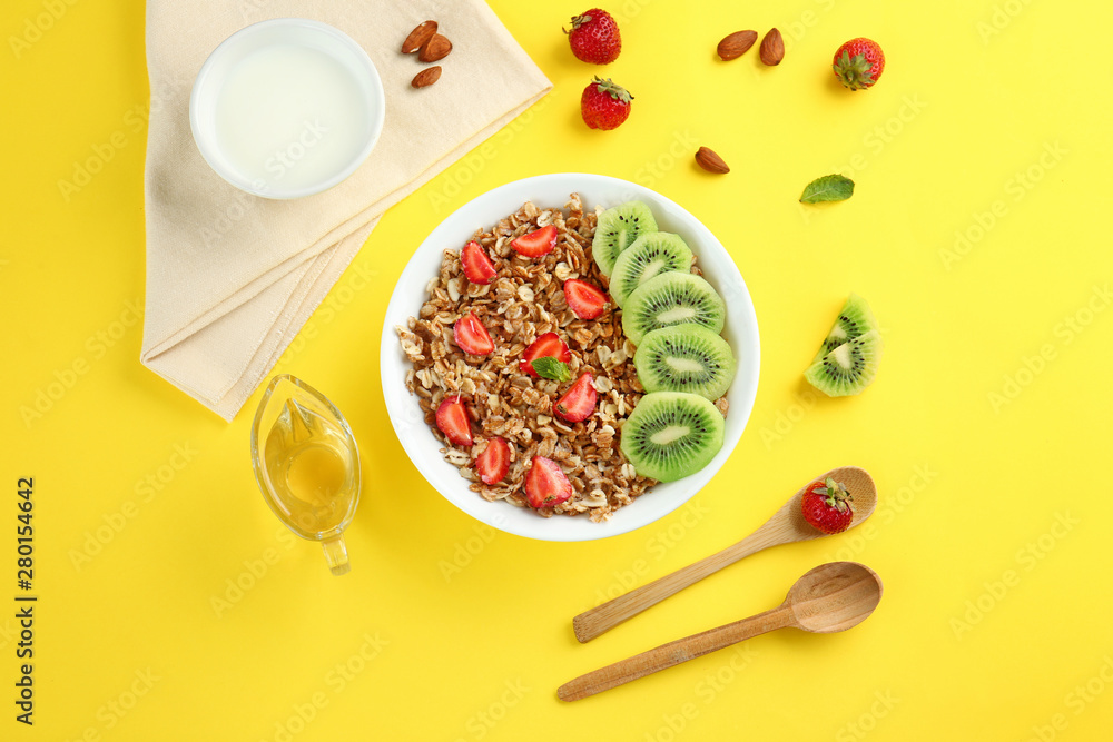 Bowl with tasty sweet oatmeal on color background