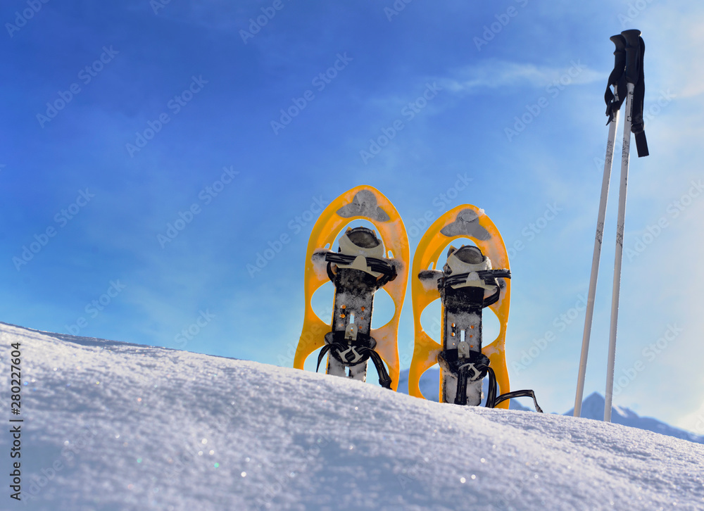 snowshoes planting in the snow in mountain under blue sky