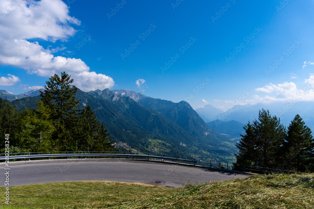 A lonely curvy street in the middle of the mountains - panoramic view