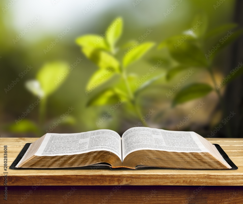 Open book on old wooden table.