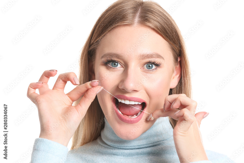 Woman flossing teeth on white background