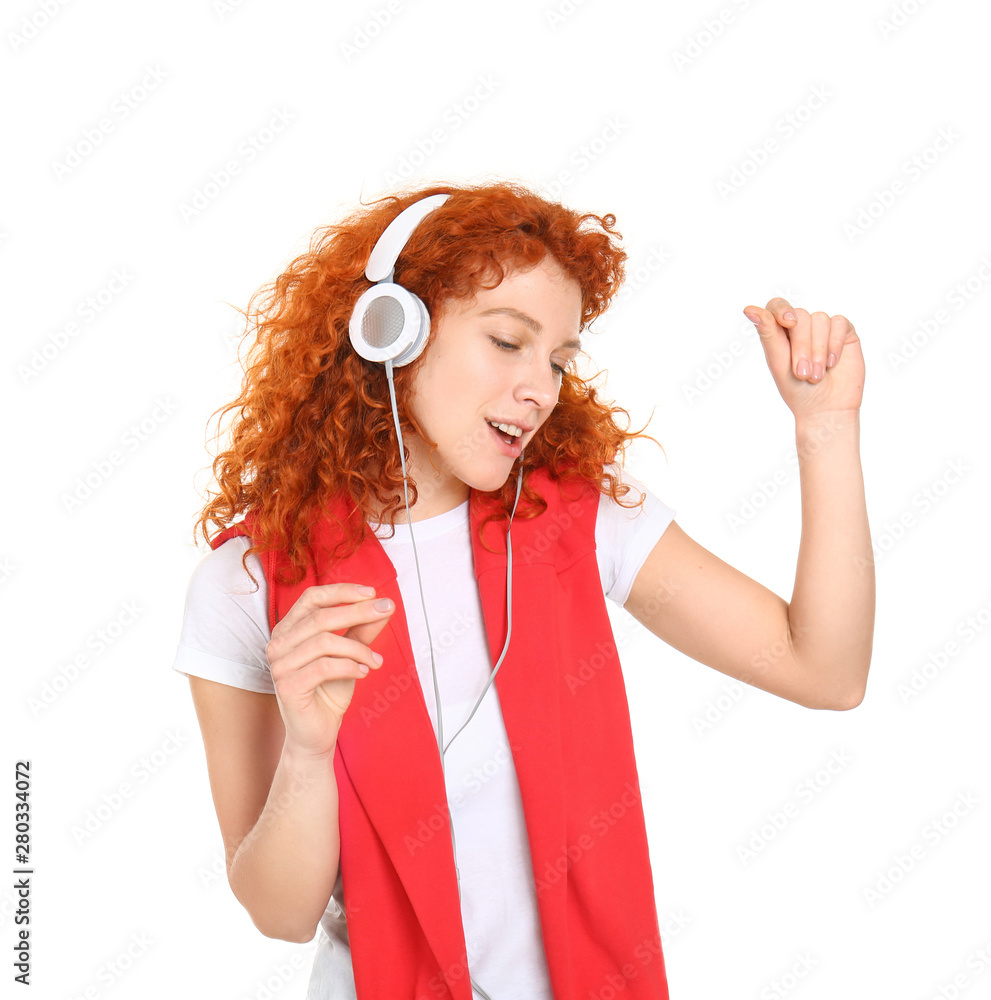 Beautiful redhead woman listening to music on white background