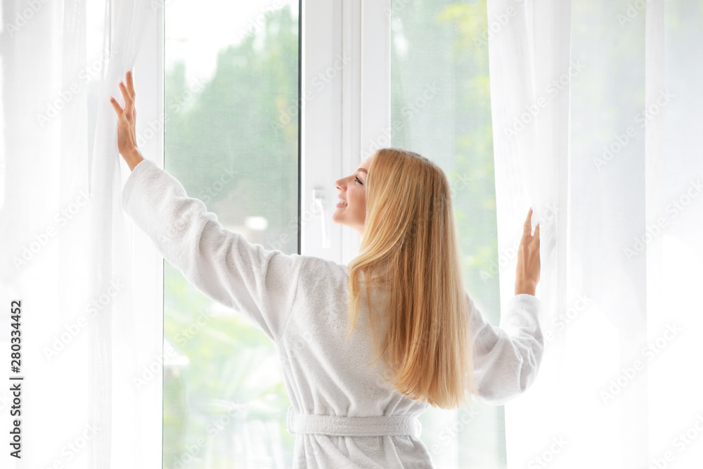 Morning of beautiful young woman near window