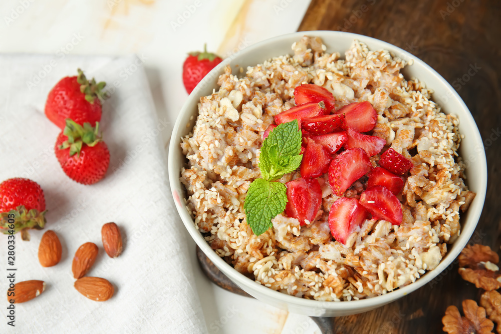 Bowl with tasty sweet oatmeal on table