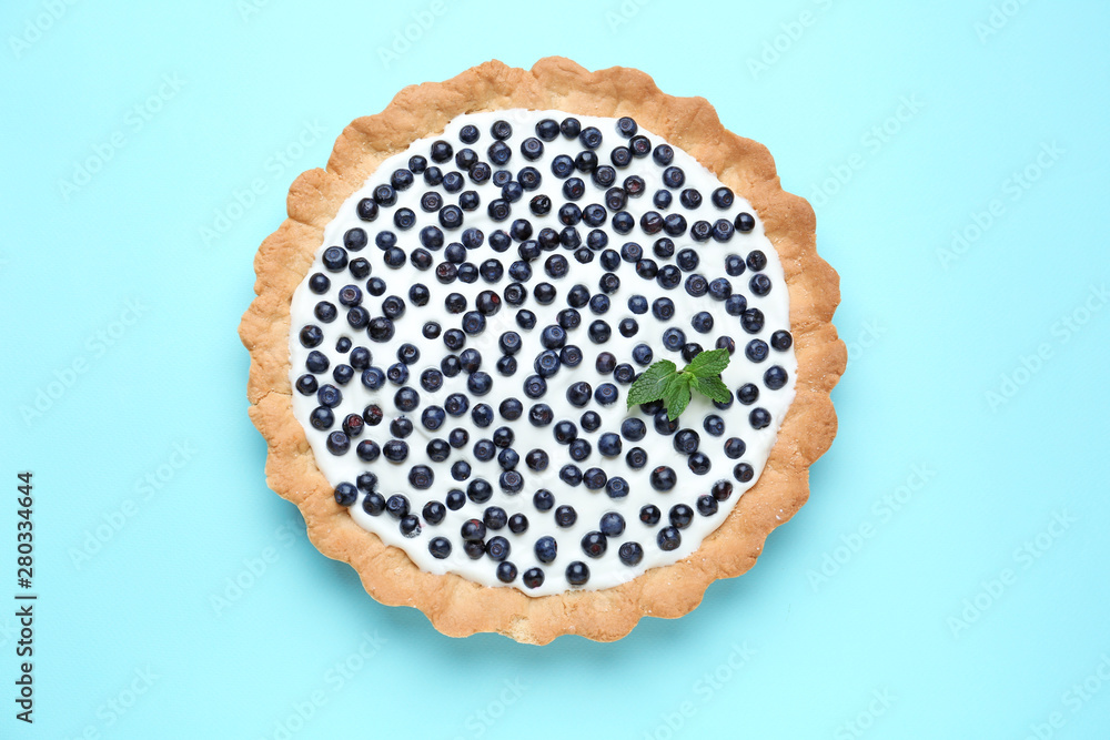 Tasty bilberry pie on color background