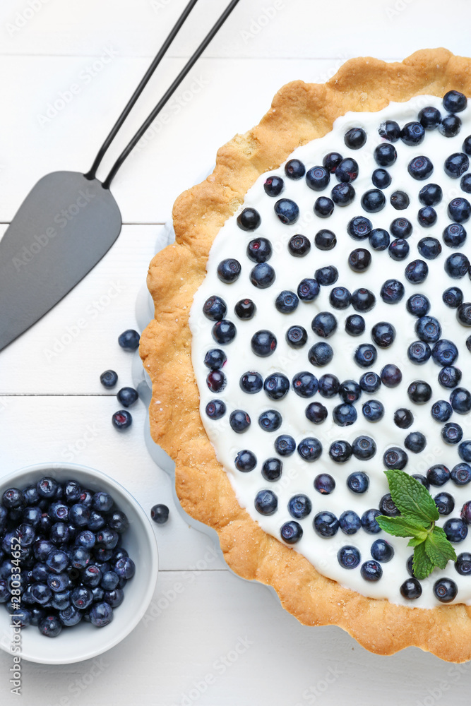 Tasty bilberry pie on white wooden background