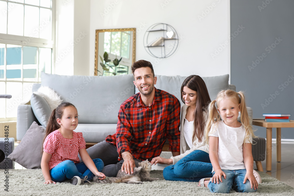 Happy family with cute cat resting at home