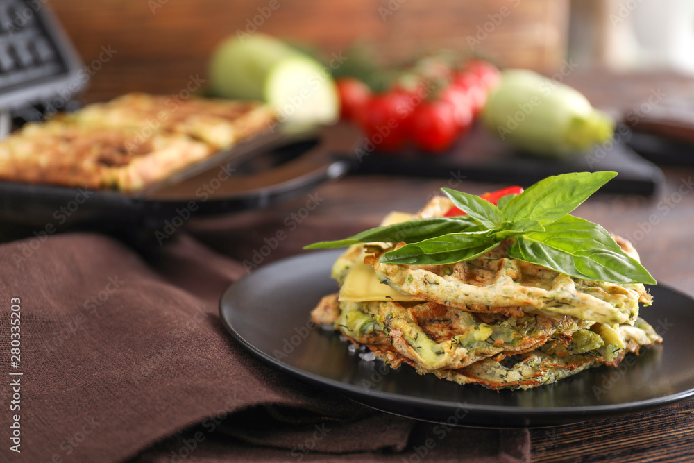 Plate with tasty squash waffles on table