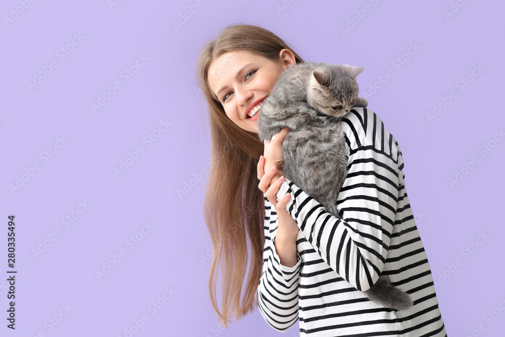 Beautiful young woman with cute cat on color background