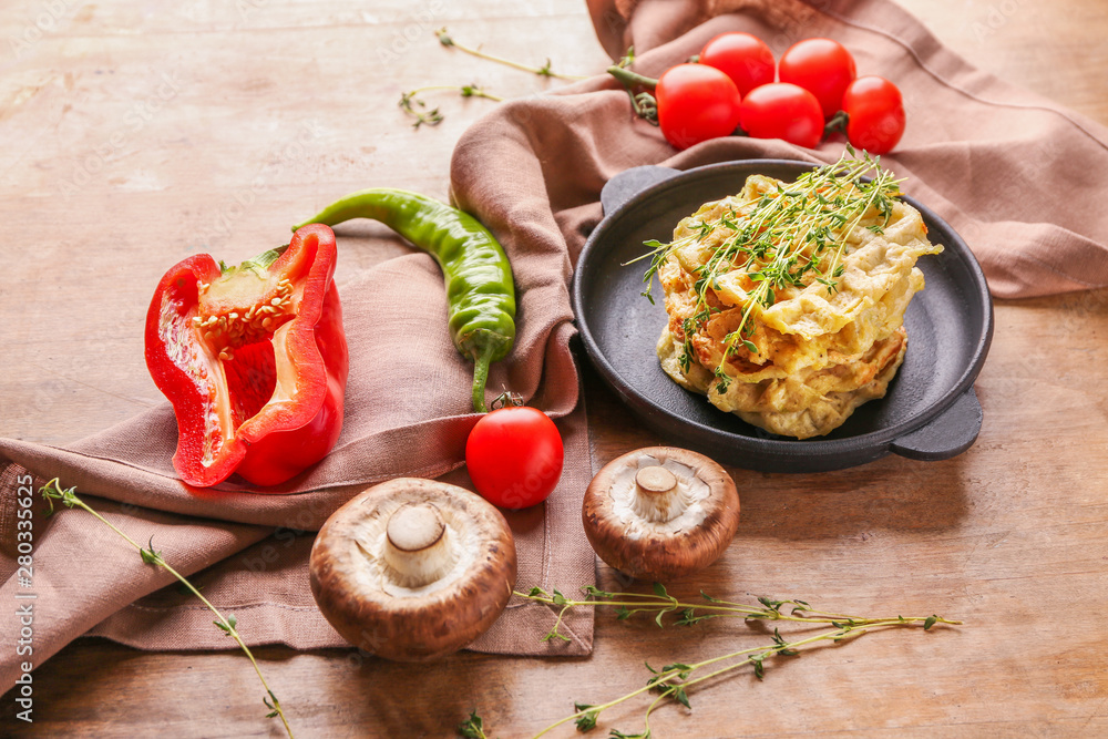 Composition with tasty squash waffles and vegetables on wooden background