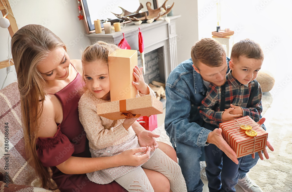 Happy family with gifts at home on Christmas eve