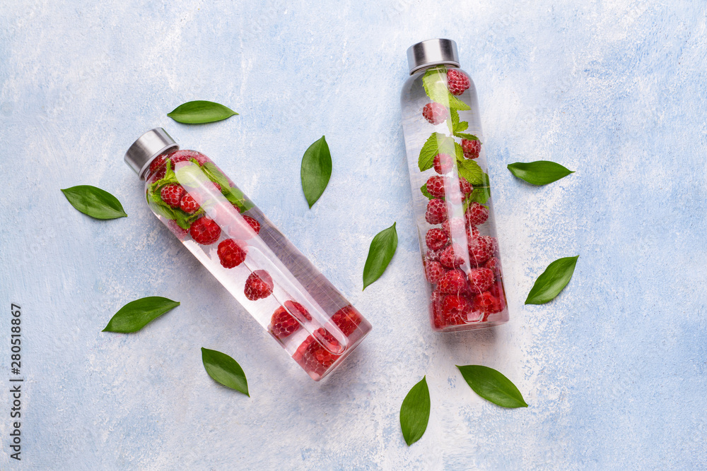 Bottles of infused water on light color background