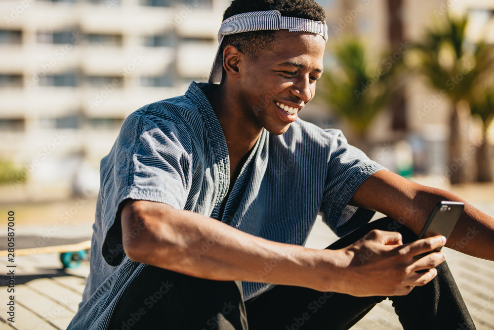 Skateboarder smiling with a mobile phone